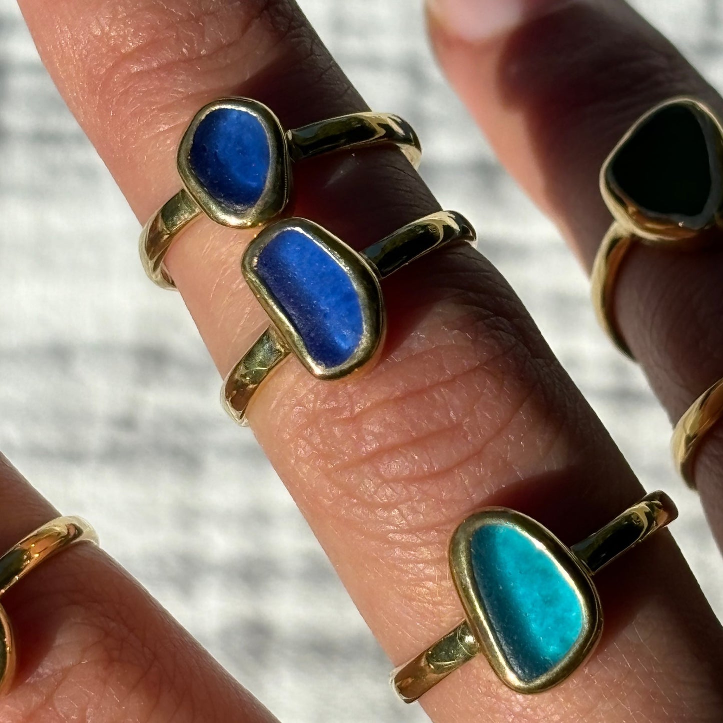 mixture of gold vermeil rings with blue sea glass in them